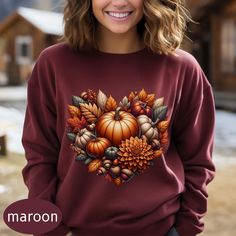 This fall sweater features Dahlia and pumpkins surrounded by autumn leaves. Perfect for those cold days to cozy up by a fire.  Gildan 18000 .: Made with a medium-heavy fabric blend of 50% cotton and 50% polyester (8.0 oz/yd² (271.25 g/m this sweatshirt feels cozy and is the perfect choice for those colder months. .: The classic fit along with the crew neckline deliver a comfy wearing experience with a clean-cut style. Meanwhile, the double-needle stitching at the shoulder, armhole, neck, waistband, and cuff seams add top-tier durability.  .: Say goodbye to itchiness thanks to the gray, pearlized tear-away label.  .: Made using 100% ethically grown US cotton. Gildan is also a proud member of the US Cotton Trust Protocol ensuring ethical and sustainable means of production. The blank tee's d Brown Crew Neck Sweatshirt For Fall, Cozy Brown Sweatshirt For Fall, Autumn Weather, Pumpkin Leaves, Heart Sweatshirt, Leaves Fall, Fall Sweater, Clean Cut, Fall Sweaters