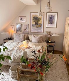 a bed room with a neatly made bed and lots of pictures on the wall above it