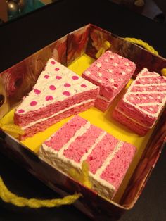 pink and white cake sitting in a box on top of a table