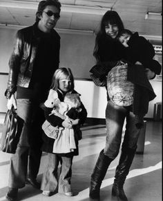 a man and two children are walking through an airport