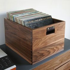 a wooden box filled with records on top of a desk