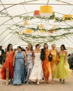 a group of women standing next to each other under a tent