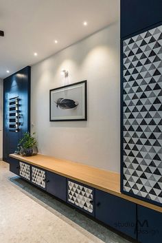 a modern entry way with blue and white decor on the wall, along with a wooden bench