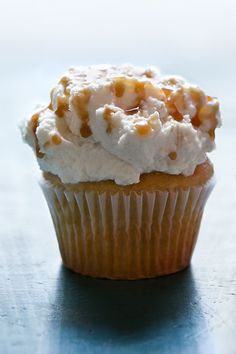 a cupcake with white frosting and caramel topping