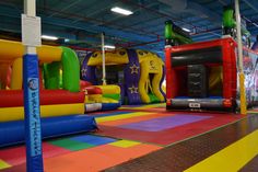 an inflatable bounce house is set up with colorful bouncy mats and slides