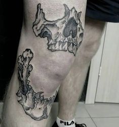 a man's leg with a skull and bones tattoo on it