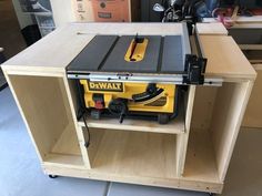 a table saw sitting on top of a wooden shelf next to a power tool box