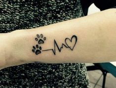 a person with a dog's paw and heartbeat tattoo on their arm