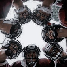 a group of football players standing in a circle with helmets on their heads and feet