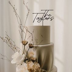 a three tiered wedding cake with flowers on top