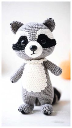 a crocheted raccoon is sitting on the table