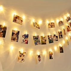 a string of lights is hanging on the wall with pictures and photos attached to it