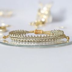 three gold bracelets sitting on top of a glass plate