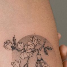 a woman's thigh with flowers and an eiffel tower tattoo