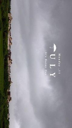 an airplane flying in the cloudy sky over a field