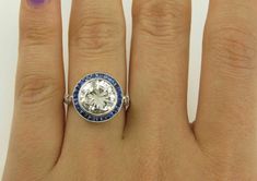 a woman's hand with a diamond and blue sapphire ring