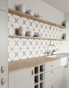 a kitchen with white cabinets and shelves filled with dishes on top of wooden counter tops