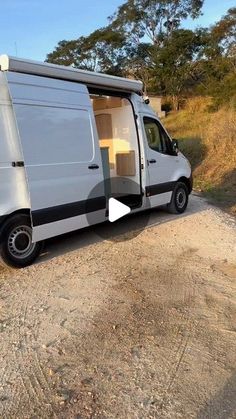 a white van parked on top of a dirt road