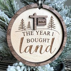 a wooden ornament that says the year i bought land