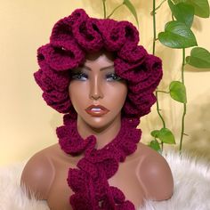 a mannequin wearing a crocheted hat and scarf with flowers on it