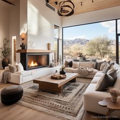 a living room filled with furniture and a fire place in front of a large window