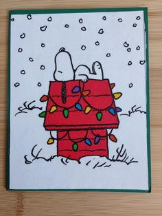 a handmade christmas card featuring a snoopy on top of a tree with lights