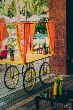 a cart with orange drapes and pineapples on the back is sitting outside