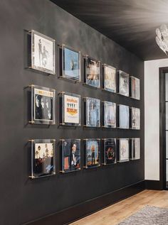 a black wall with pictures on it and a chandelier