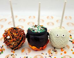 three decorated donuts sitting next to each other on top of a table with sprinkles