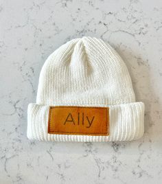 Beautiful personalized sublimated vegan leather patches that are hand pressed and hand sewed onto each beanie! These beanies are the perfect unique gift for the all! Select from beanies sized from Infants, toddlers to kids/adults. These beanies would be great as an individual gift or a gift for your whole family! Choose between a variety of colors and fonts to make each beanie truly unique for each recipient. Casual White Beanie As Gift, Handmade Adjustable White Beanie, White Handmade Adjustable Beanie, Infant Beanie, Ribbed Knit Beanie, Patch Beanie, Kids Beanies, Custom Leather, Leather Patches