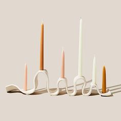 four candles are lined up in the shape of scissors with one candle sticking out of it