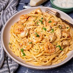 a plate of pasta with shrimp and parmesan cheese