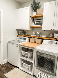 a washer and dryer in a small laundry room with open shelving on the wall