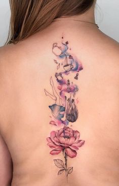 a woman's back tattoo with flowers on it