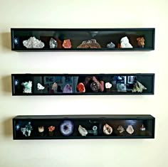 two black shelves filled with different types of rocks and crystals on top of each shelf