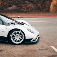 a white sports car driving down the road