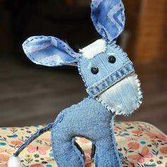 a denim donkey stuffed animal sitting on top of a cushion