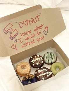 a box filled with donuts sitting on top of a bed