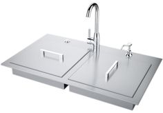 a stainless steel sink with two faucets on it