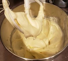 a metal bowl filled with white batter on top of a counter