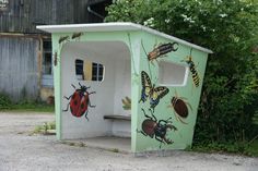 a painted outhouse with bugs and insects on it