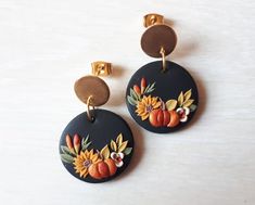 pair of earrings with painted pumpkins and sunflowers