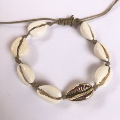 White and Gold cowrie shell choker, cowrie shell necklace, sea shell necklace, gold shell necklace, cuff choker necklace, shell jewelry Gorgeous white and gold cowrie shell choker with bracelet or anklet bracelet with sea inspiration. This cowrie shell necklace is perfect for several styles: boho, minimalist, modern, chic... The necklace, bracelet, and anklet bracelet are adjustable in length with a sliding knot, so that you can wear it short or long and the cord ends in four delicate endings wi White Cowrie Shell Bracelet, Gold Cowrie Shell As Gift, Gold Cowrie Shell Jewelry For Gift, Gold Shell-shaped Bracelet For Vacation, Trendy Shell-shaped Jewelry Gift, Cowrie Shell Festival Bracelets, Gold Shell Bracelet For Vacation, Gold Sliding Knot Jewelry For Vacation, Beachy Shell Bracelet Jewelry