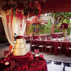 a wedding cake sitting on top of a table covered in red and white cloths