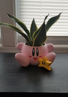 a potted plant sitting on top of a wooden table next to a yellow star