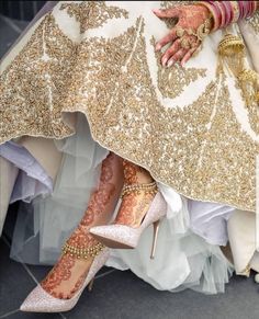 a bride's feet with gold and white shoes