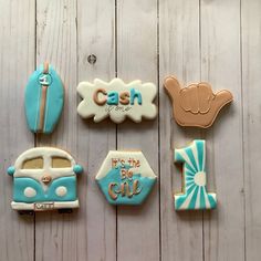 decorated cookies are arranged in the shape of cars, trucks, and letters on a white wooden surface