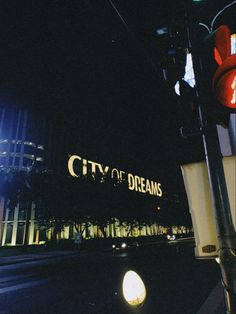 the city of dreams sign is lit up at night