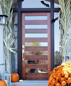 the front door is decorated with pumpkins and flowers