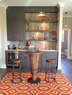 a kitchen with gray cabinets and an orange rug